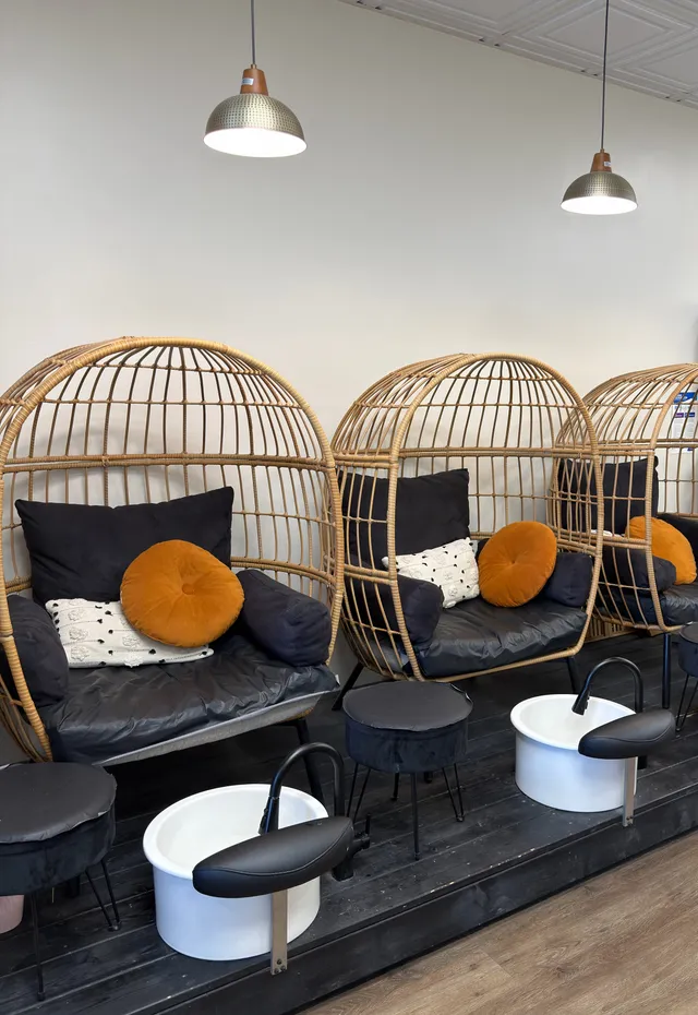 Pedicure area with three rattan egg chairs and foot basins